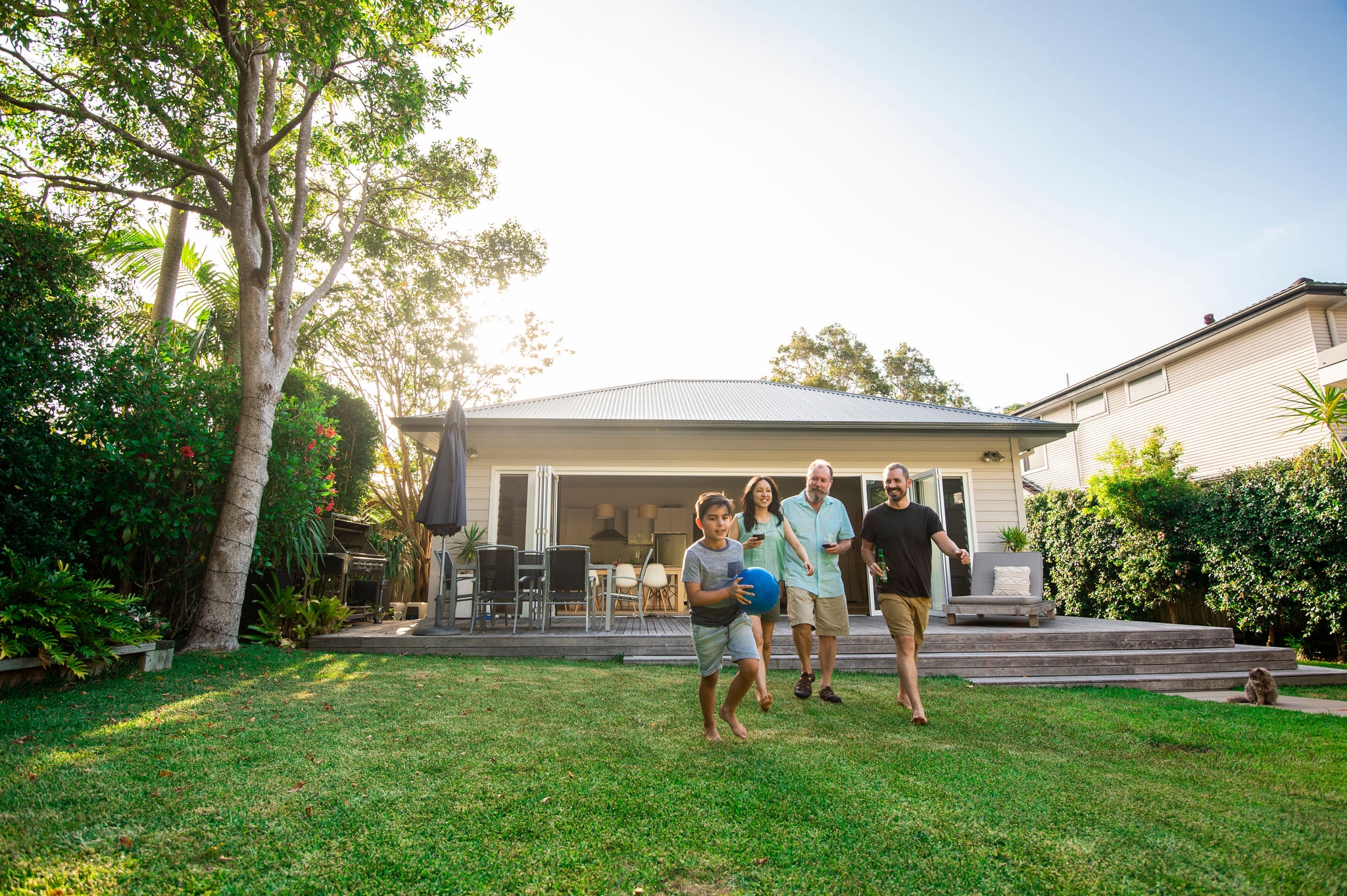 Typical Australian bungalow, family enjoying evening soccer game.