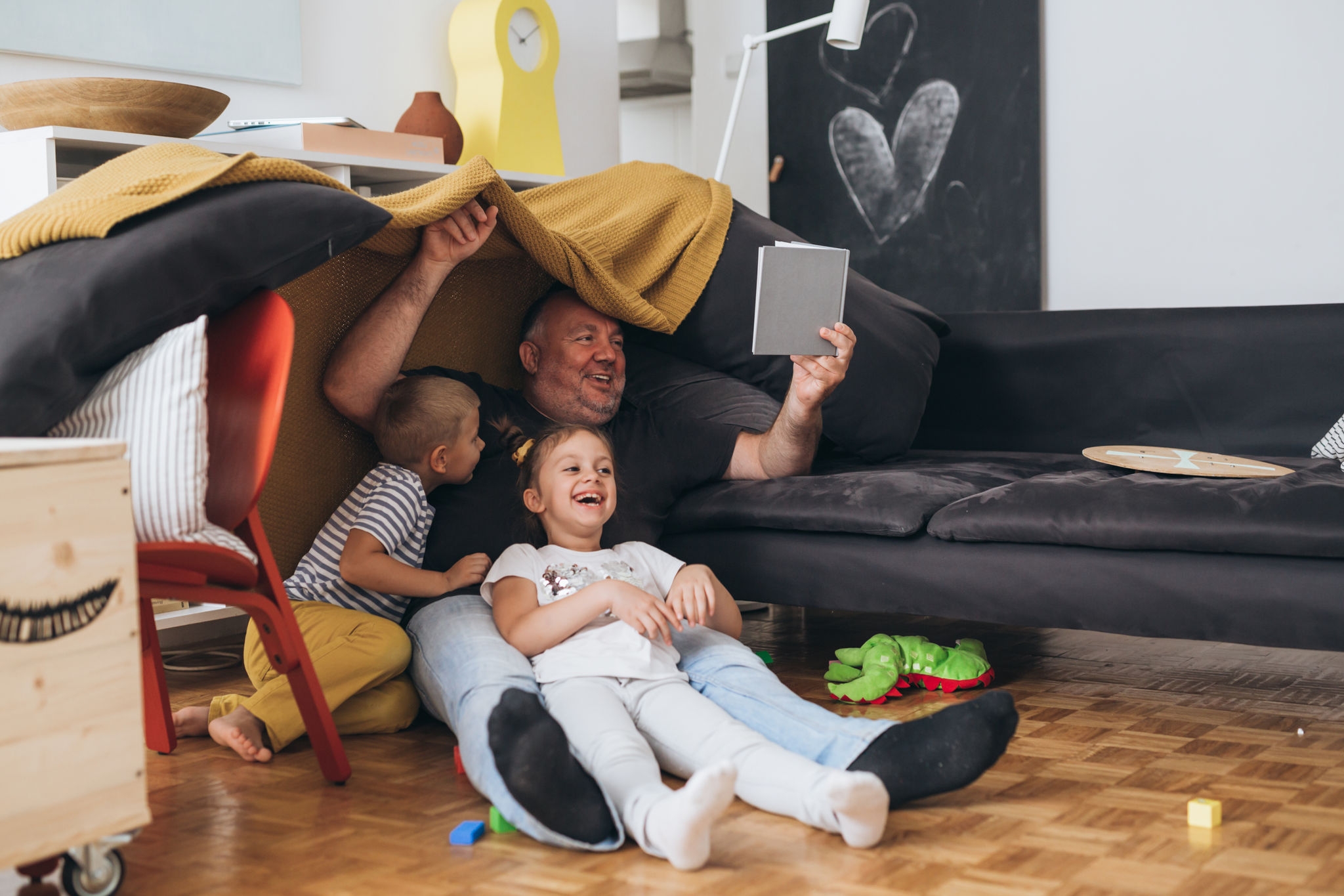 father playing with children at home